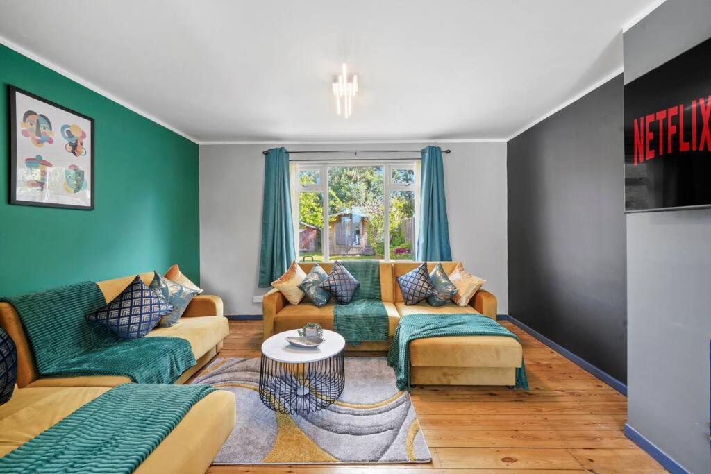 ein Wohnzimmer mit 2 Sofas und einem Tisch in der Unterkunft Spacious Luxury Garden House Free Parking in Bristol