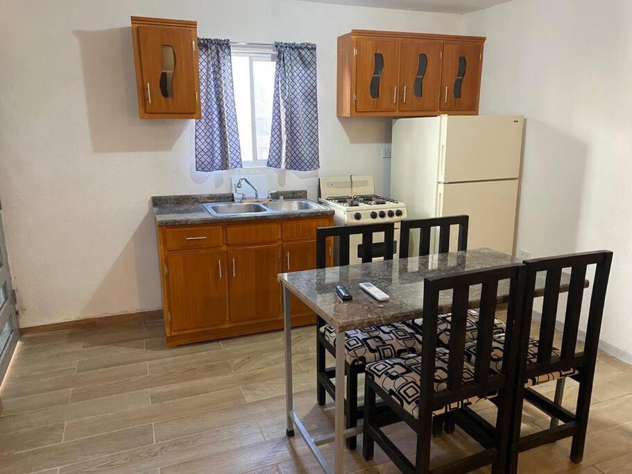 cocina con mesa, sillas y nevera en Bonito departamento tipo “estudio” 2, en Ciudad Juárez