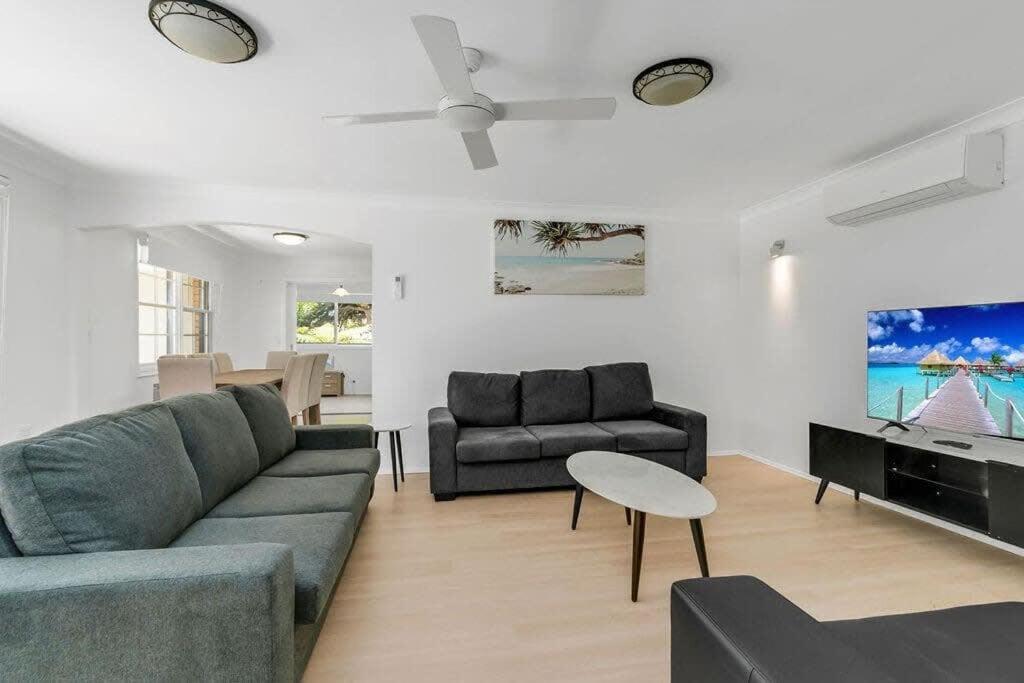uma sala de estar com um sofá e uma mesa em Lakeside Family Oasis - Oak Flats em Albion Park