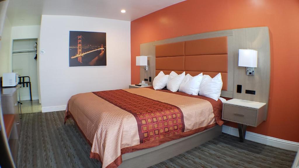 Habitación de hotel con cama con pared de color naranja en Presidio Parkway Inn en San Francisco