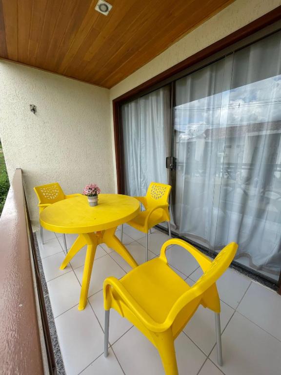 a yellow table and chairs on a balcony at Flat 1218, no residencial monte castelo in Bezerros