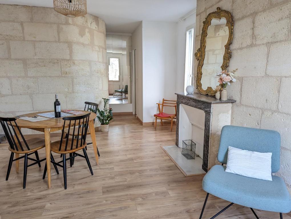 una sala da pranzo con tavolo, sedie e camino di Lumineux appartement sous les toits à Pey Berland a Bordeaux