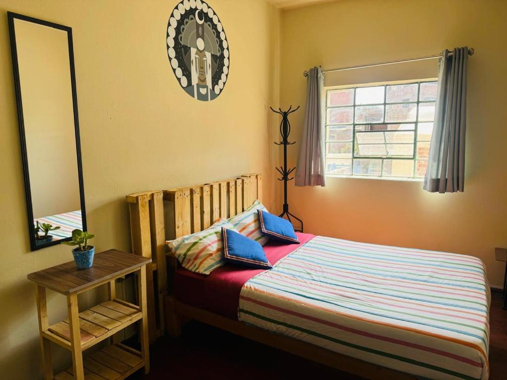 1 dormitorio con cama y espejo en Maison Verte - Budget Edition, en Arequipa