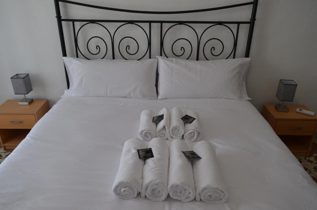 Una cama blanca con tres toallas enrolladas. en Casa del riu., en Riola