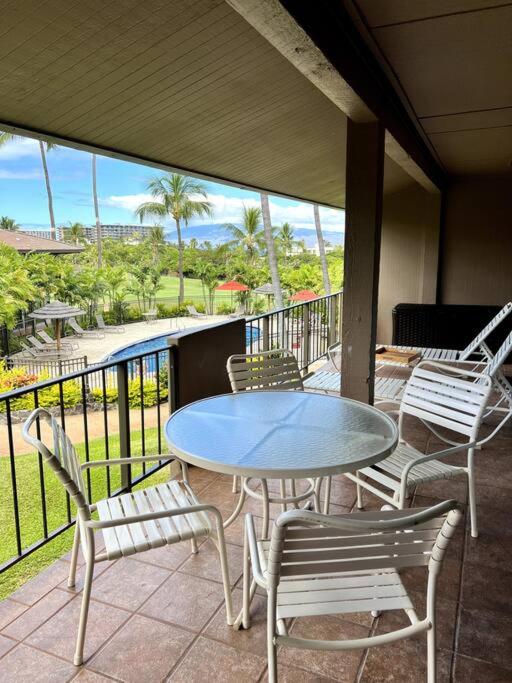 a patio with a table and chairs on a balcony at IslandVista 1BR: Ocean & Golf Bliss in Kahana