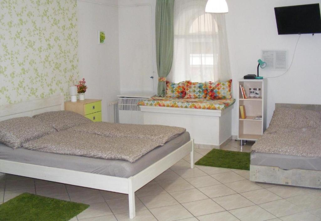 een slaapkamer met 2 bedden en een raam bij Fortuna Apartmanok Eger in Eger