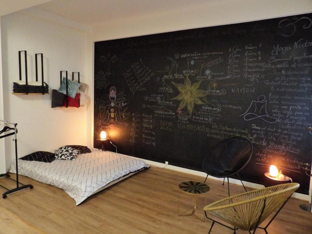 - une chambre dotée d'un mur avec un lit et des chaises dans l'établissement Studio japonisant, à Nice