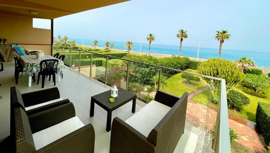 balcón con mesa, sillas y vistas al océano en Appartamento "La casa du Capu", en Capo dʼOrlando