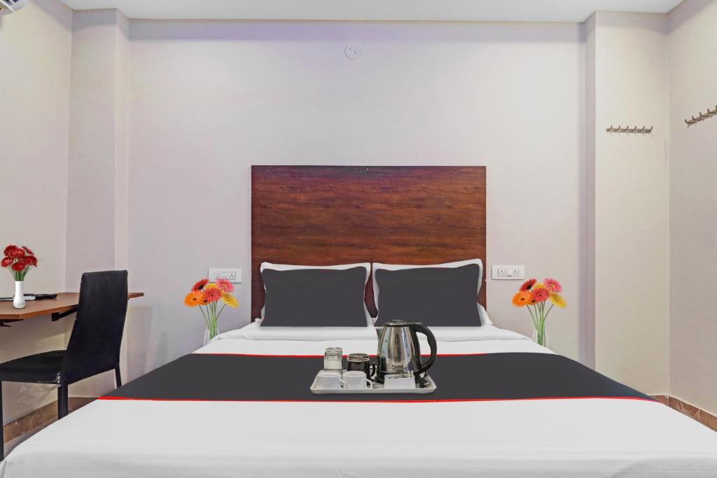 ハイデラバードにあるSrinika Innのベッドルーム1室(ベッド1台、デスク、テーブル付)