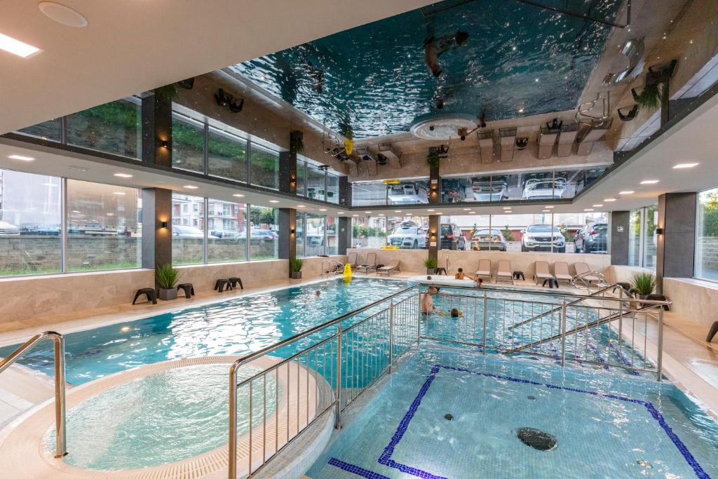 a swimming pool in a hotel with a large indoor swimming pool at Apartament 6M Rewal w cenie basen, jacuzzi, siłownia, sala zabaw, free private parking, Park Rozrywki HOSSOLAND 30 minut in Rewal