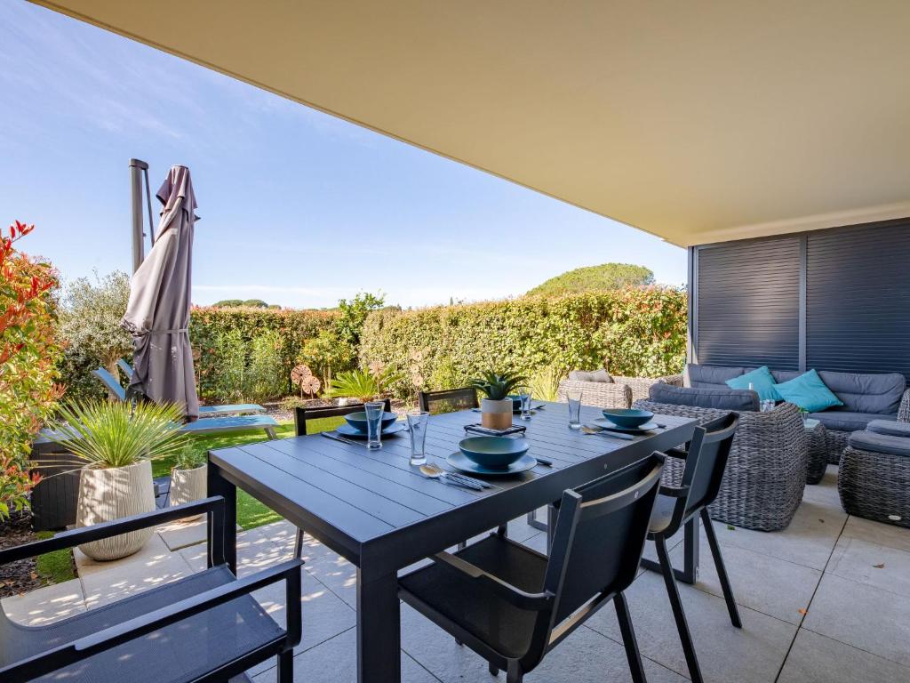 Une table à manger et des chaises sont disponibles sur la terrasse. dans l'établissement Apartment Golfe Horizon-3 by Interhome, à Fréjus