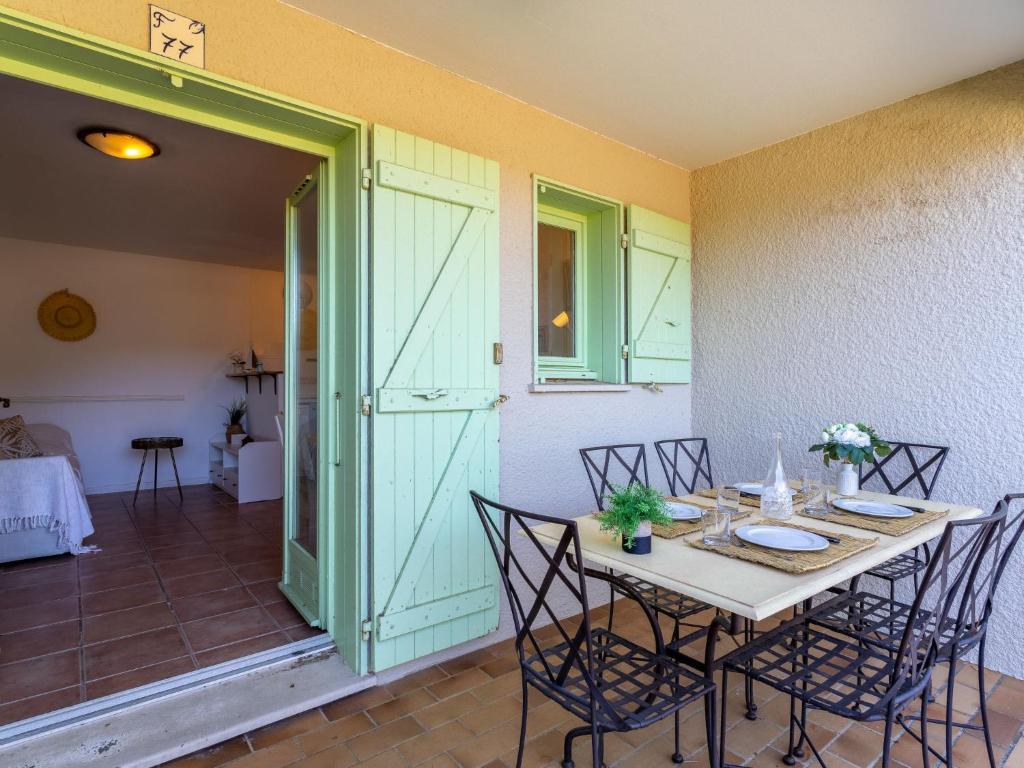 une salle à manger avec une table, des chaises et une porte dans l'établissement Apartment Cap Négre - Domaine de la Pinède-21 by Interhome, au Lavandou