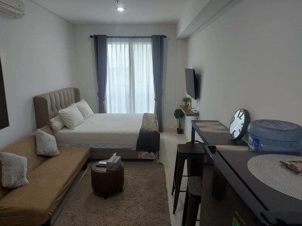 Comfy Studio with City View @BorneoBay Residence في Klandasan Kecil: غرفة صغيرة بها سرير وأريكة