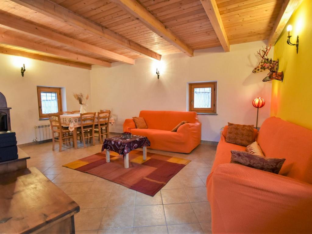 ein Wohnzimmer mit orangefarbenen Möbeln und einem Tisch in der Unterkunft Holiday Home Dubino Home by Interhome in Dubino