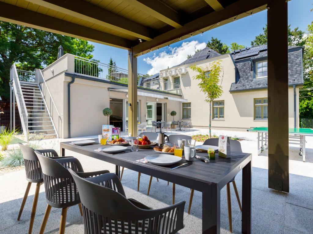 zona de comedor al aire libre con mesa de madera y sillas en Apartment Park 3 by Interhome en Balatonszárszó