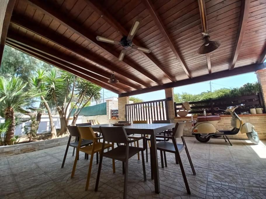 einen Tisch und Stühle auf einer Terrasse mit Deckenventilator in der Unterkunft Casa vacanze a 100mt dal mare in Torre Ovo