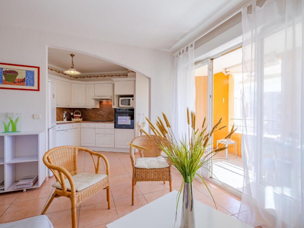 une cuisine et un salon avec une table et des chaises dans l'établissement Apartment Terre du Soleil-2 by Interhome, à Sainte-Maxime
