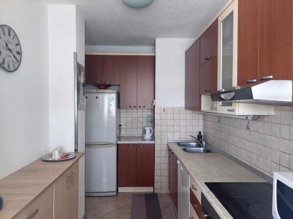 een keuken met houten kasten en een witte koelkast bij Apartman Maja in Banja Luka