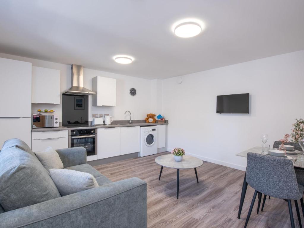 ein Wohnzimmer und eine Küche mit einem Sofa und einem Tisch in der Unterkunft Studio Harbour Nights 7B by Interhome in Lossiemouth