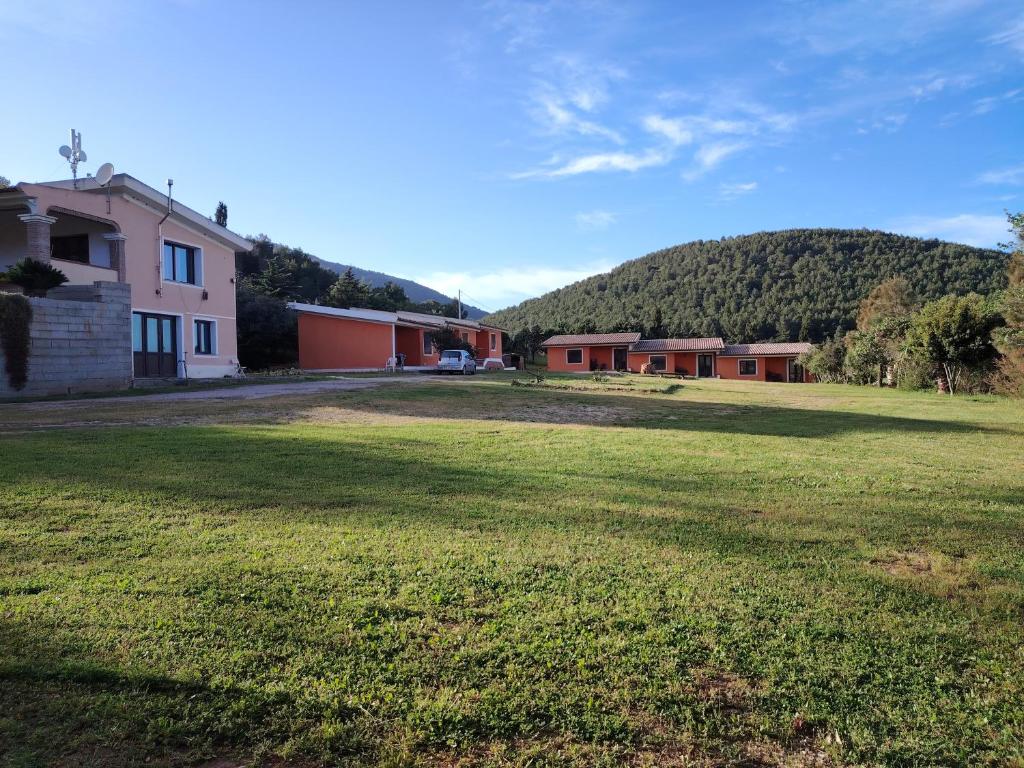 a large yard with houses and a hill in the background at Agriturismo Arena Del Sol in Fertilia