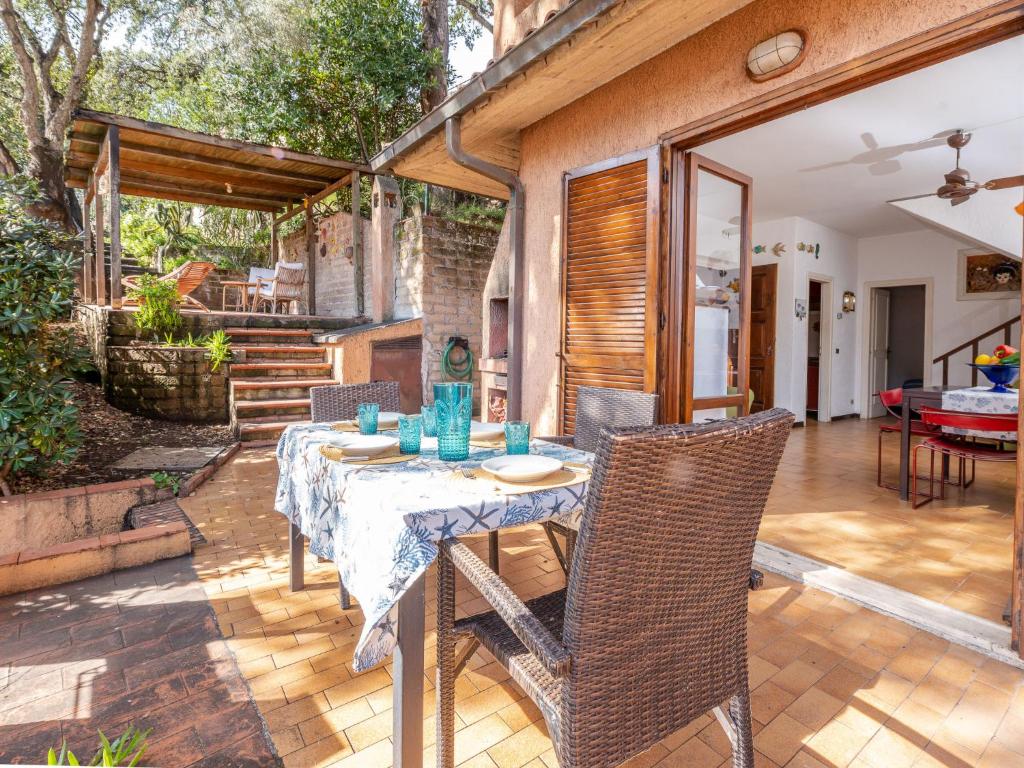 comedor con mesa y sillas en el patio en Holiday Home Le Sughere by Interhome en Porto Ercole