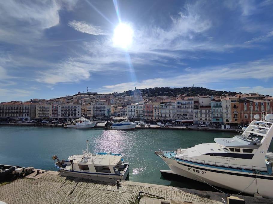 deux bateaux sont amarrés dans un port avec des bâtiments dans l'établissement Grand T3 sur quai vue St-clair, à Sète