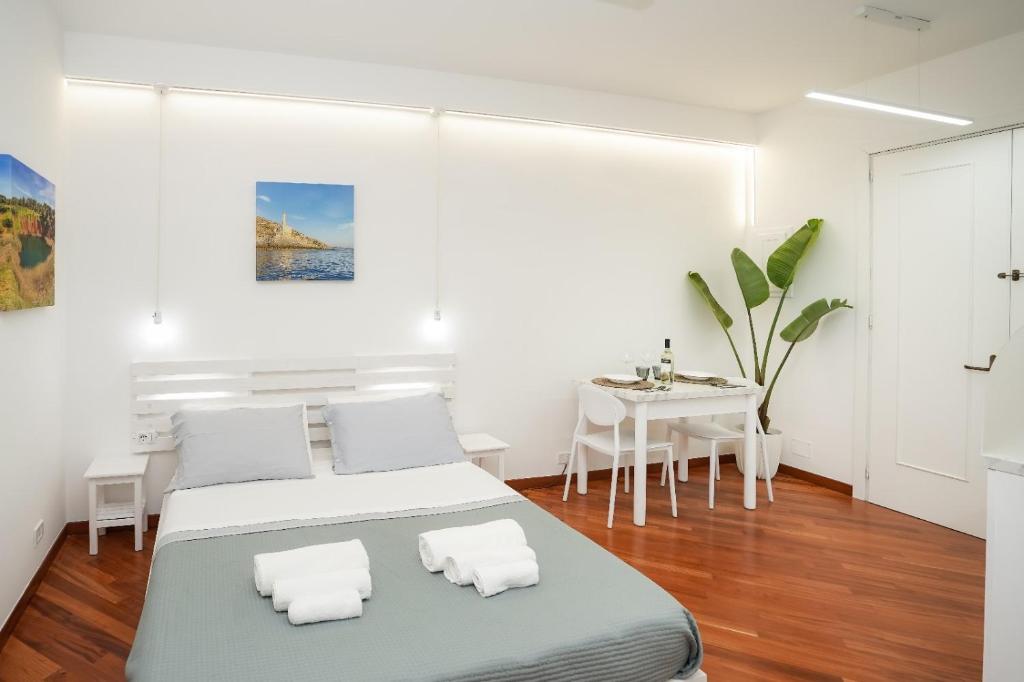 una camera bianca con due letti e un tavolo di Due metri sopra al mare a Otranto