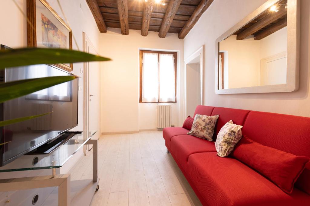 a living room with a red couch and a tv at Intero Appartamento AnticaValle in Verona