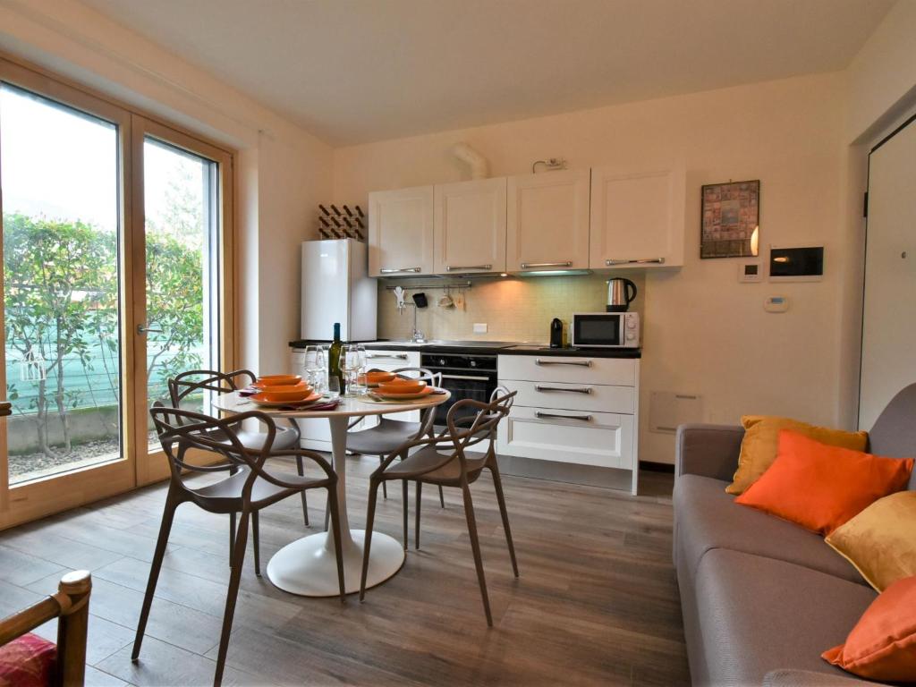 uma cozinha e sala de estar com mesa e cadeiras em Apartment Olmo Garden Apartment by Interhome em Morbegno