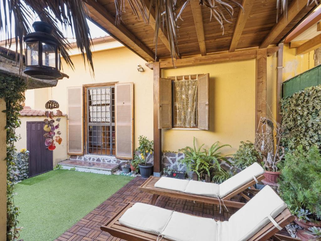 um pátio com mobiliário branco e uma casa em Holiday Home Mimosa by Interhome em Lido dei Pini