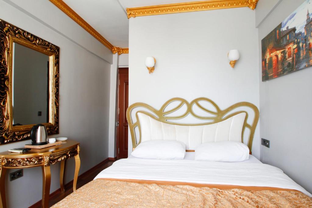 een slaapkamer met een bed en een spiegel bij Californiacityhotel in Istanbul