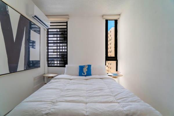 uma grande cama branca num quarto com janelas em Budget-Friendly Haven- Comfort & Convenience em San Juan