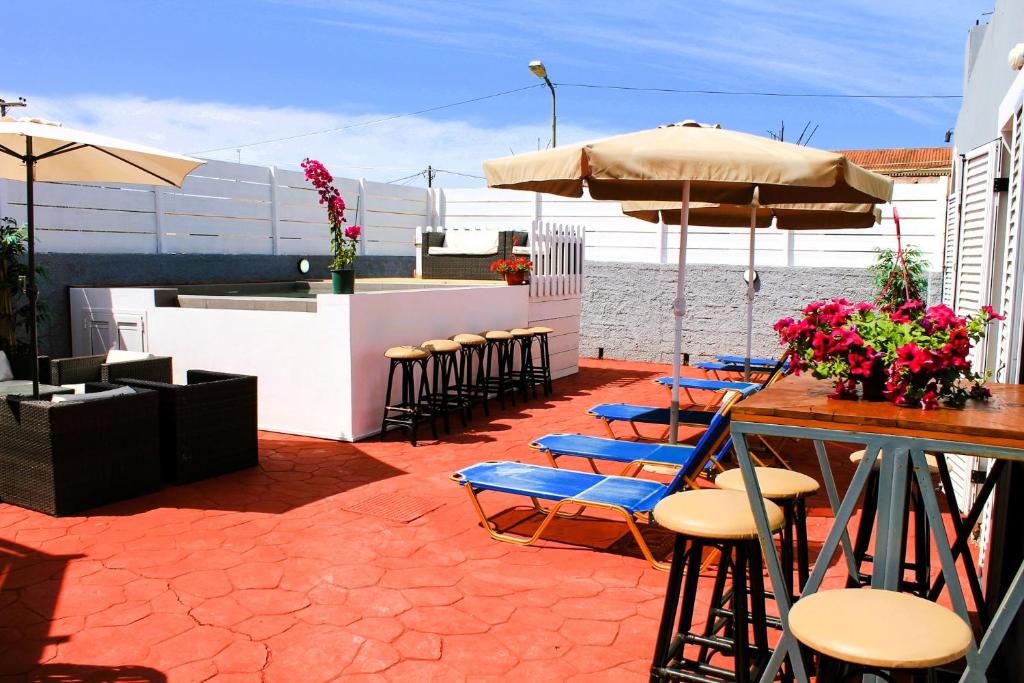 a patio with chairs and a table with an umbrella at Villa Kouros in Melíssia