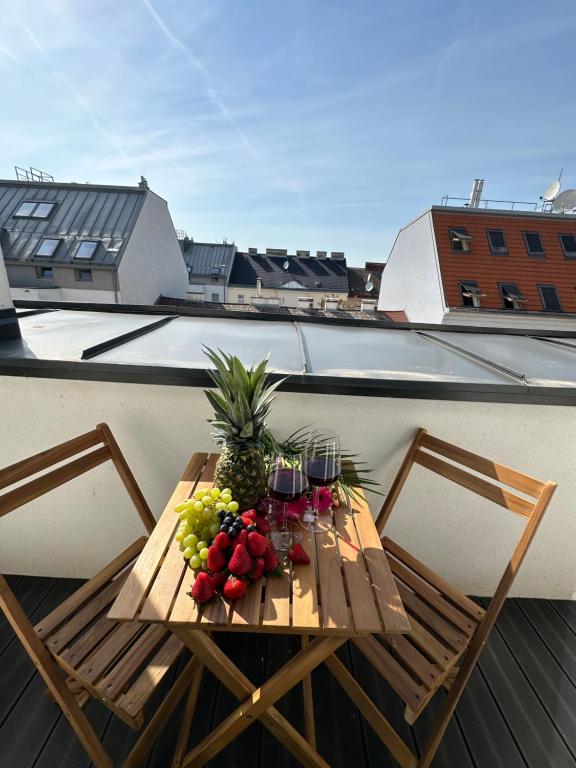 een tafel met fruit- en wijnglazen op een balkon bij Swan Stay Property 17 in Wenen