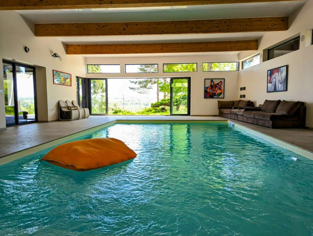 uma piscina com uma bola laranja numa casa em Villa de 7 chambres avec vue sur la ville piscine interieure et jardin clos a Parmain a 2 km de la plage em Parmain