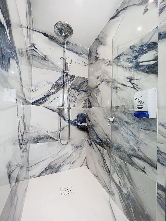 a bathroom with a shower with marble walls at Hotel Noguera El Albir in Albir
