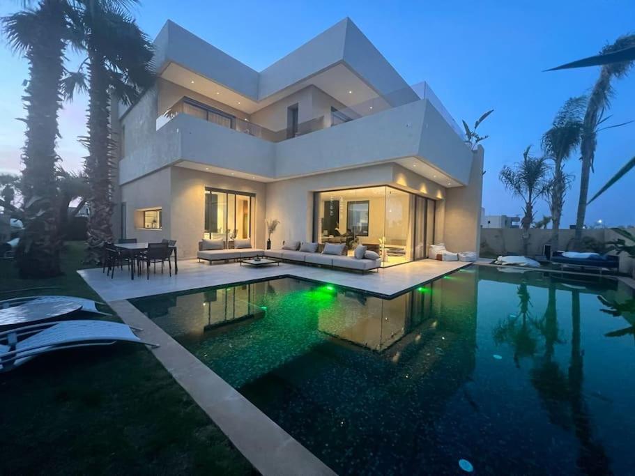 a large house with a swimming pool in front of it at villa in Marrakesh