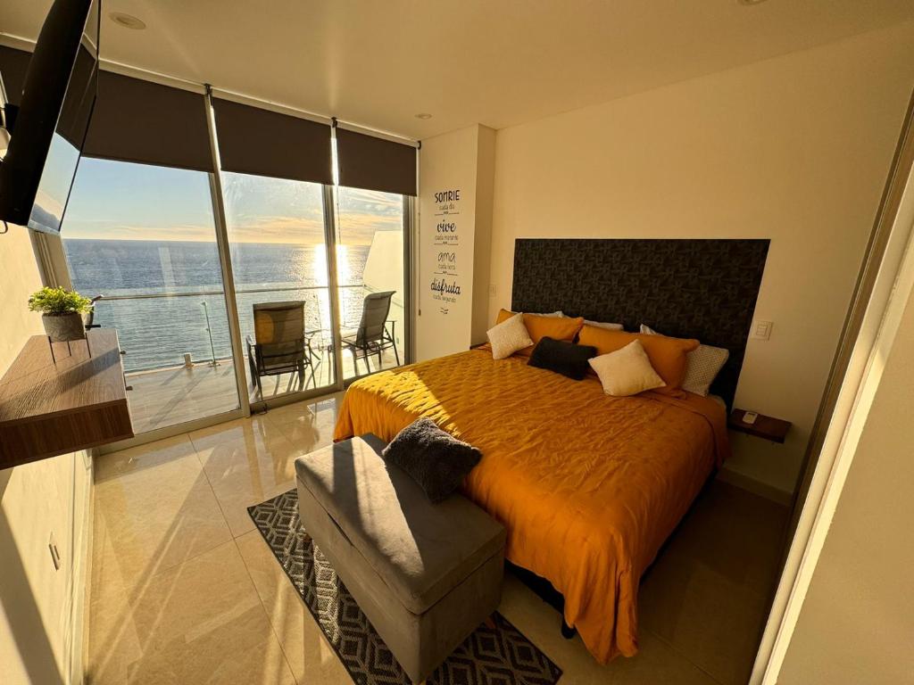 1 dormitorio con 1 cama grande y balcón en Departamento a pie de playa en Camino al Mar en Mazatlán
