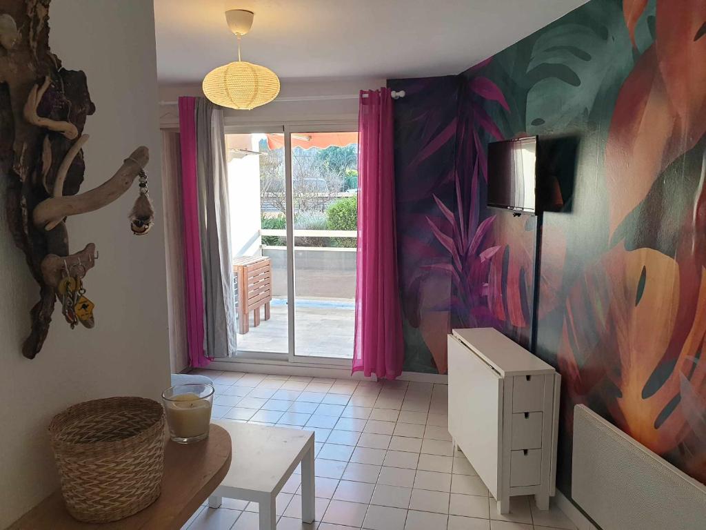 - un salon avec une porte donnant sur une terrasse dans l'établissement Studio idéal séjour en amoureux rez de jardin proche plage, à Bormes-les-Mimosas