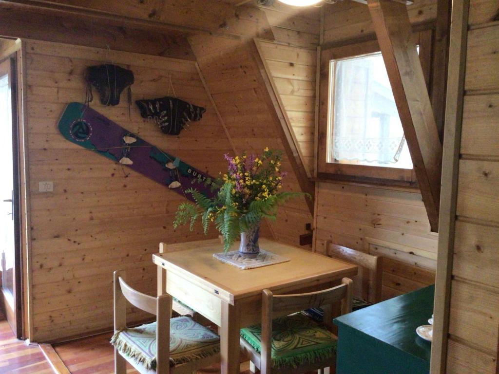 Chalet Natura Sport&Relax في Cavaliere: غرفة مع طاولة مع إناء من الزهور