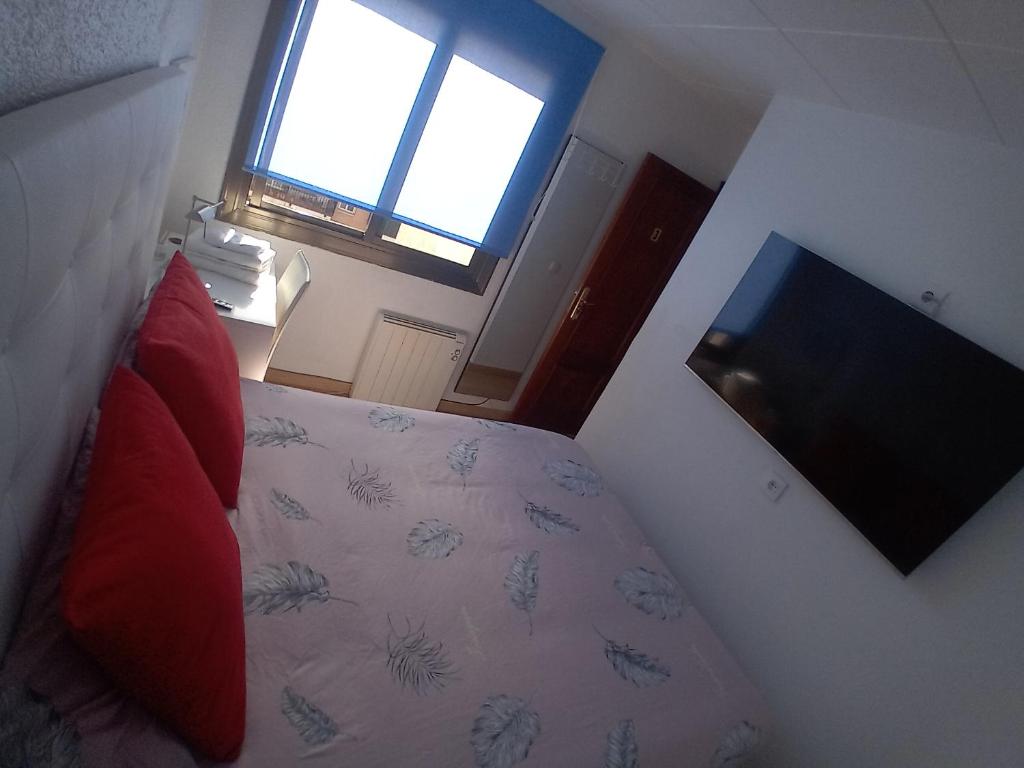 a bedroom with a bed and a window and a television at Apartamento compartido excelente ubicación in El Prat de Llobregat