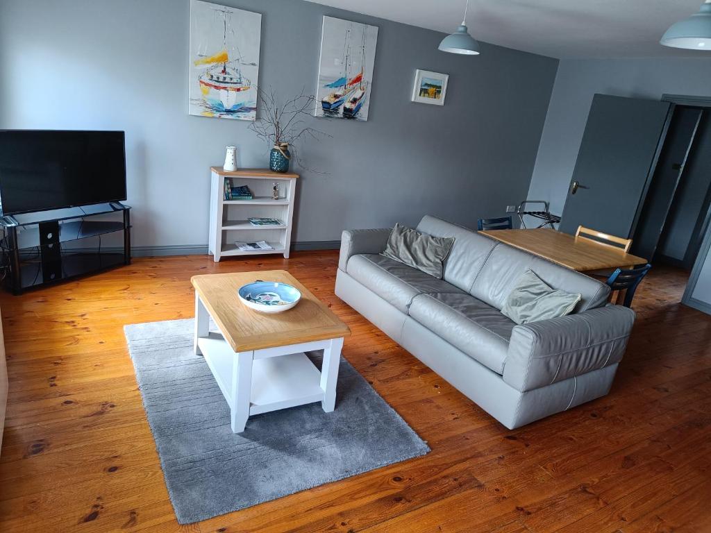 a living room with a couch and a table at Dingle Town Center Apartment in Dingle