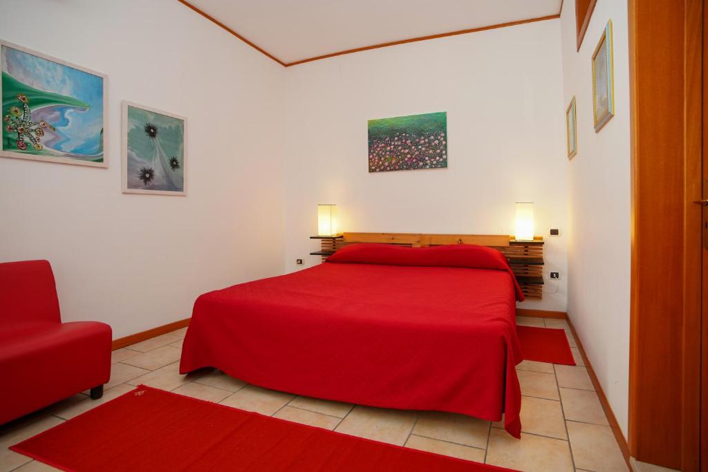 1 dormitorio con cama roja y silla roja en RESIDENCE LUPIAE, en Lecce