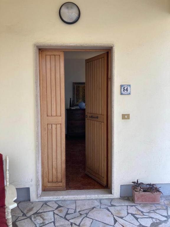 drzwi do pokoju z zegarem na ścianie w obiekcie Casa Assunta w mieście Donoratico
