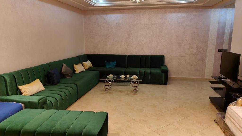 a living room with a green couch and a tv at Medina 2 in Fez
