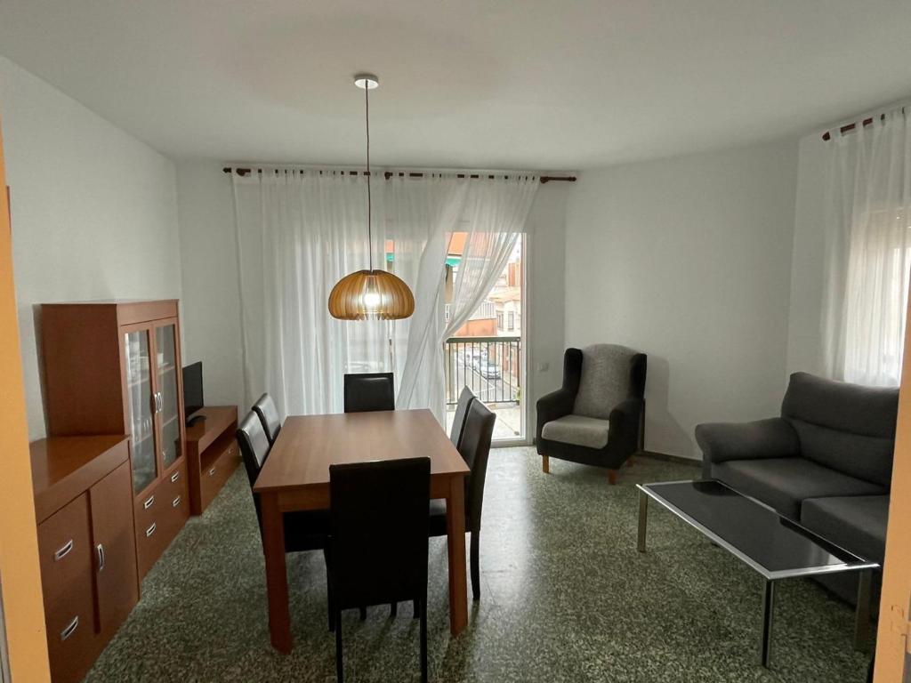 - un salon avec une table, des chaises et un canapé dans l'établissement Apartamento con Feng Shui, à Calafell