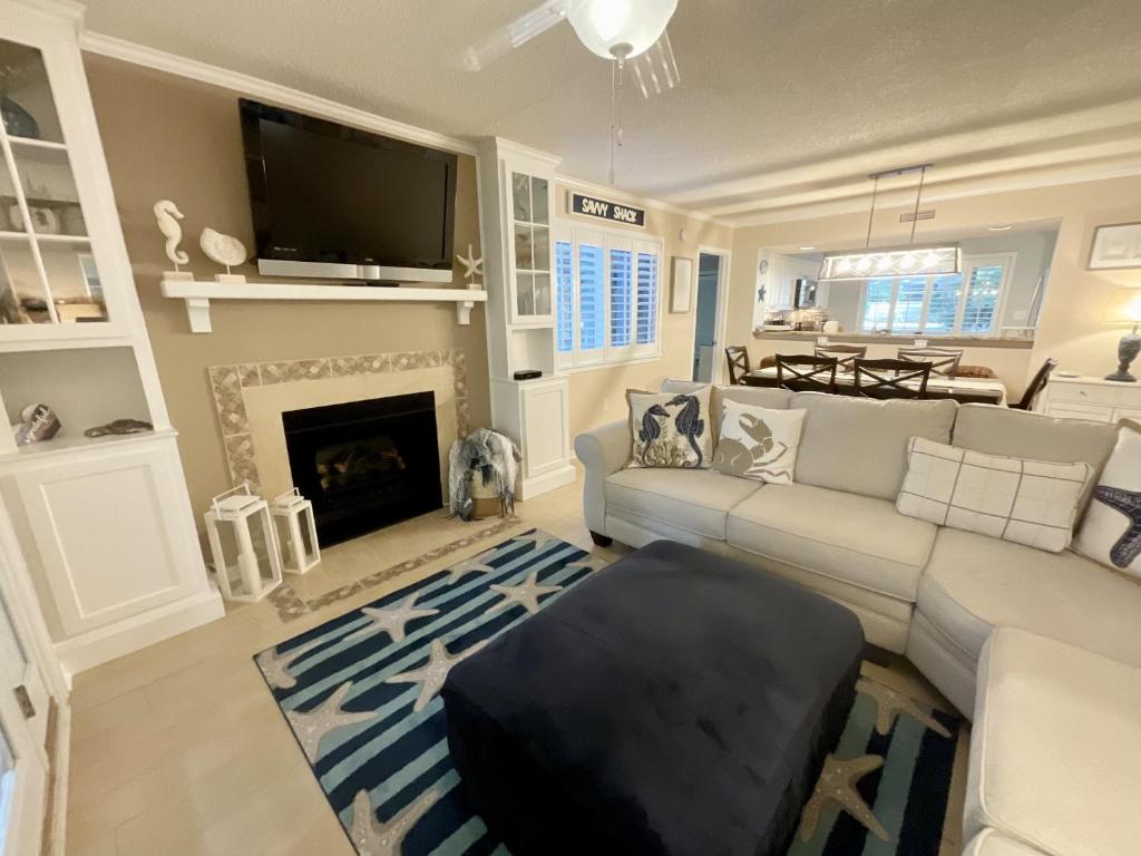 ein Wohnzimmer mit einem Sofa und einem Kamin in der Unterkunft 21C Richmond Park villa in Myrtle Beach