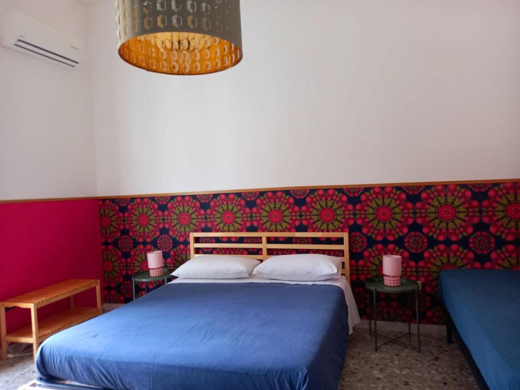 - une chambre avec un lit bleu et un mur coloré dans l'établissement CaraFe'&CaraSpe', à Naples