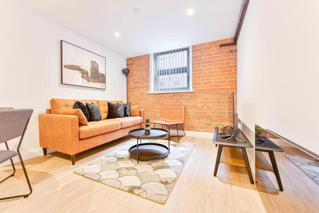 a living room with a couch and a brick wall at Lovely 2 Bed Apartment in Burton-on-Trent in Burton upon Trent