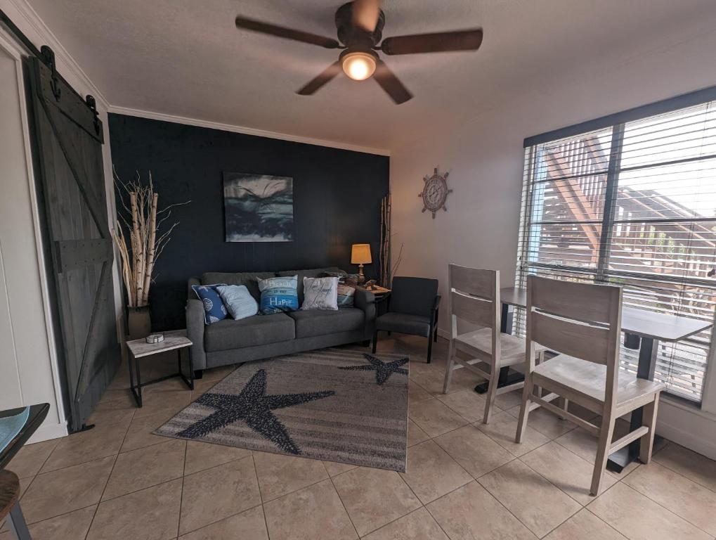 a living room with a couch and a ceiling fan at Blue Moon (Mustang Isle #11) in Port Aransas